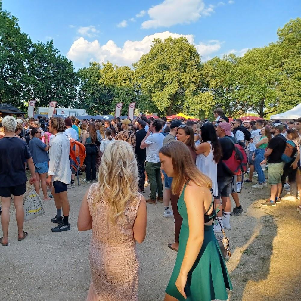 A large group of people stand in a park.